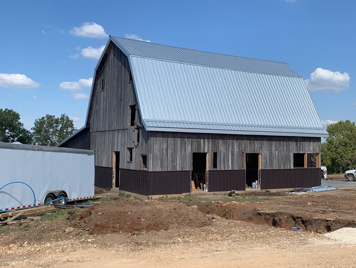 Barn renovation with new metal roof and lower siding