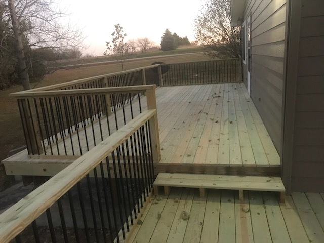 New wood deck with stairs and black metal balusters