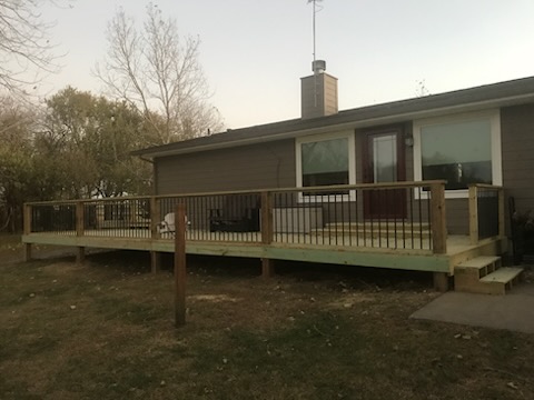 Long wood deck with black metal balusters