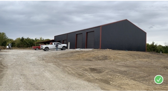Large black pole barn with multiple overhead doors