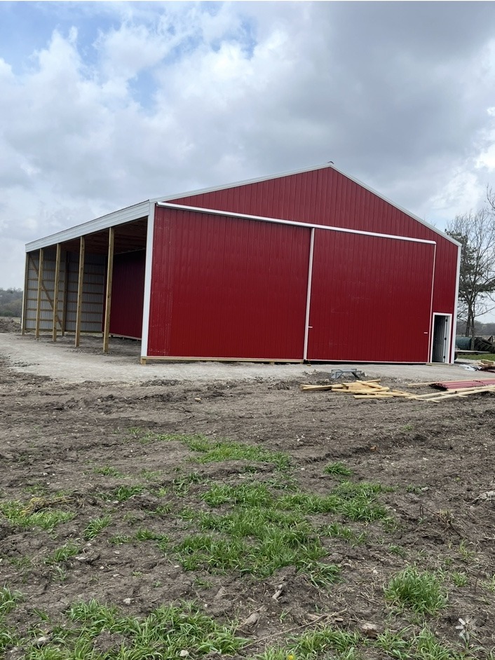 Red pole barn with large sliding doors