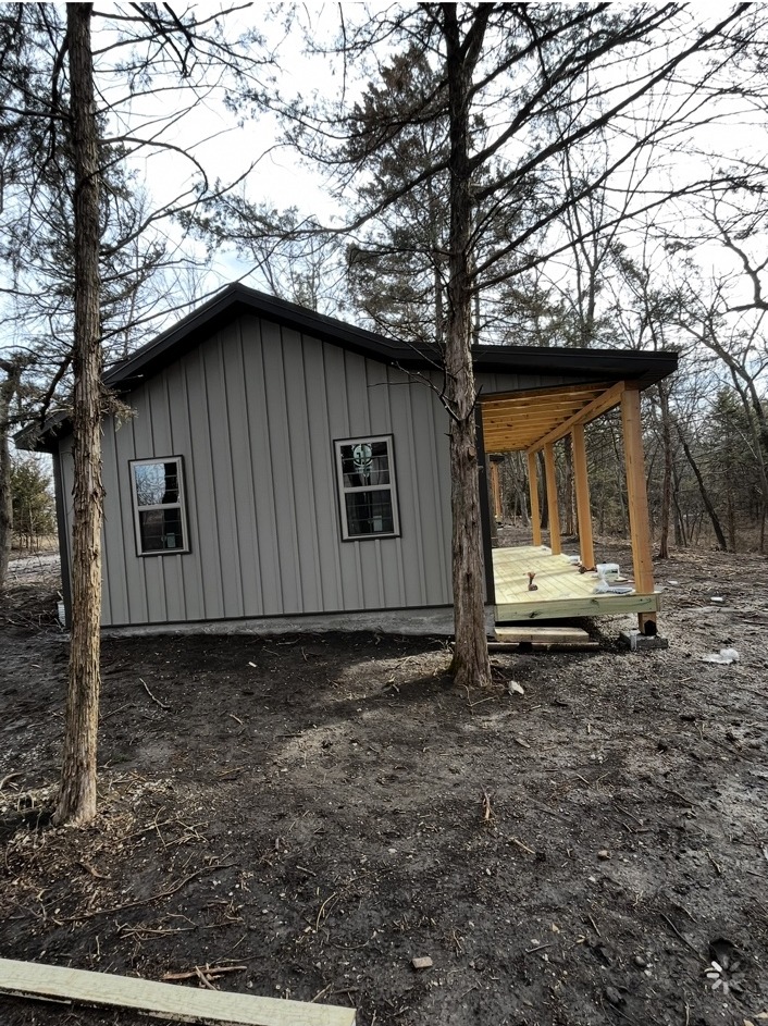 Small metal-sided home with covered wood deck